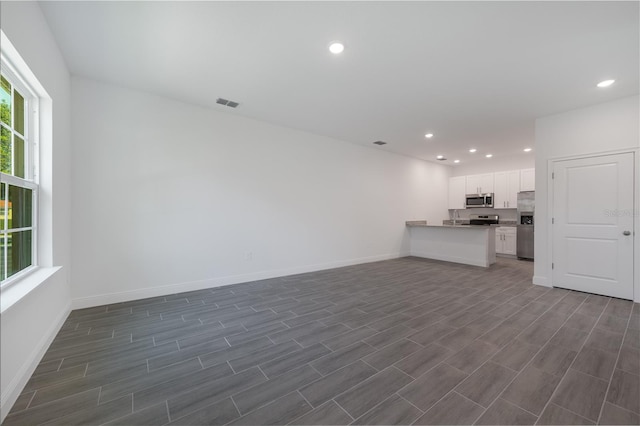 unfurnished living room with dark hardwood / wood-style floors