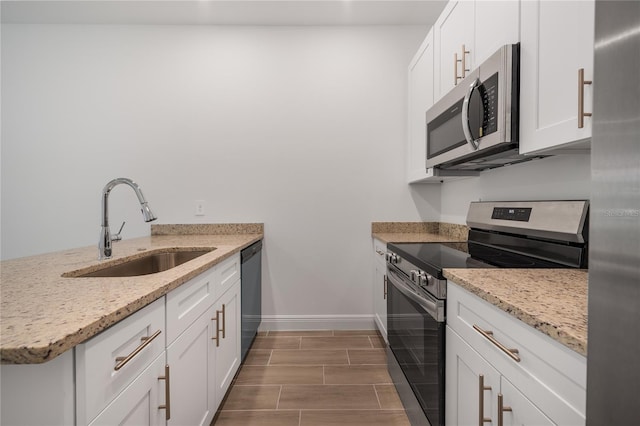 kitchen with appliances with stainless steel finishes, sink, and white cabinetry