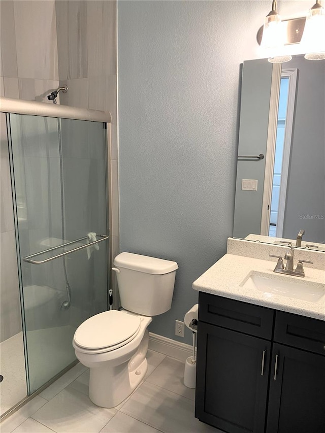 bathroom featuring tile patterned floors, an enclosed shower, vanity, and toilet