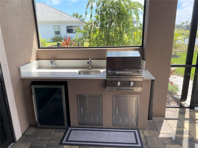 view of patio with exterior kitchen, wine cooler, grilling area, and sink