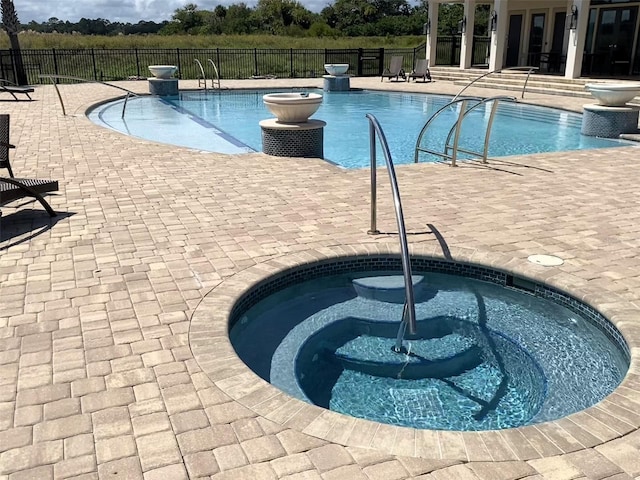 view of swimming pool with a patio and an in ground hot tub