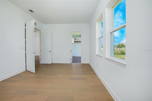 interior space with light wood-type flooring, a walk in closet, and a closet