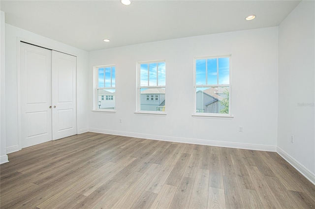 unfurnished bedroom with light hardwood / wood-style floors and a closet