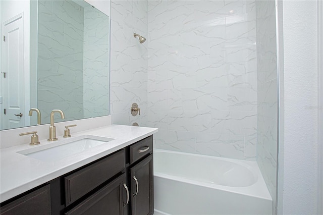 bathroom featuring tiled shower / bath combo and vanity