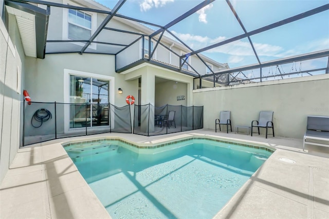 view of swimming pool featuring glass enclosure and a patio