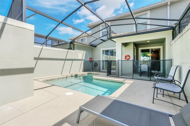 view of pool with a jacuzzi, glass enclosure, and a patio area