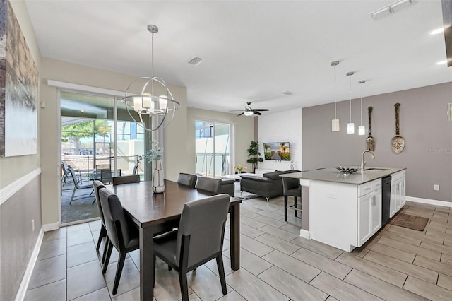 dining room featuring ceiling fan with notable chandelier and sink