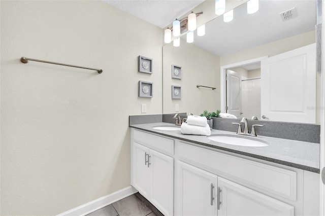 bathroom featuring tile patterned floors, a textured ceiling, walk in shower, and vanity