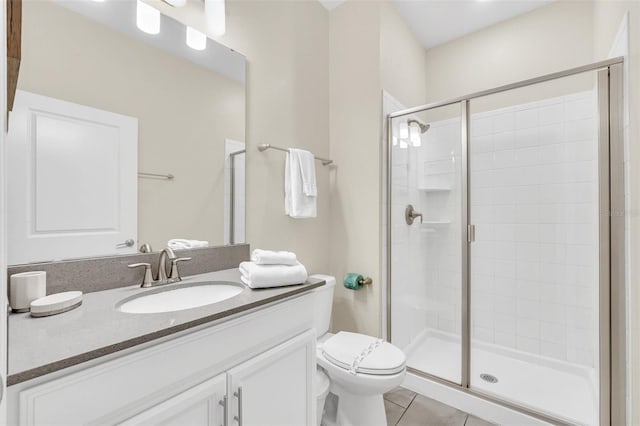 bathroom with tile patterned flooring, vanity, toilet, and a shower with door