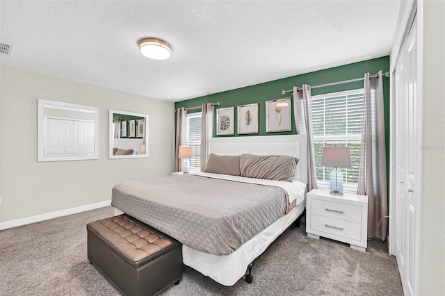 carpeted bedroom with a closet and a textured ceiling