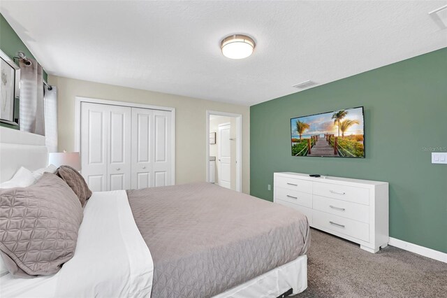 carpeted bedroom featuring a textured ceiling and a closet