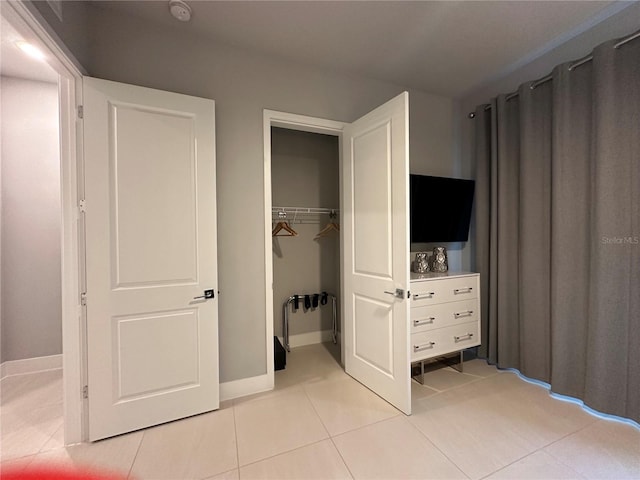 unfurnished bedroom with light tile patterned flooring and a closet