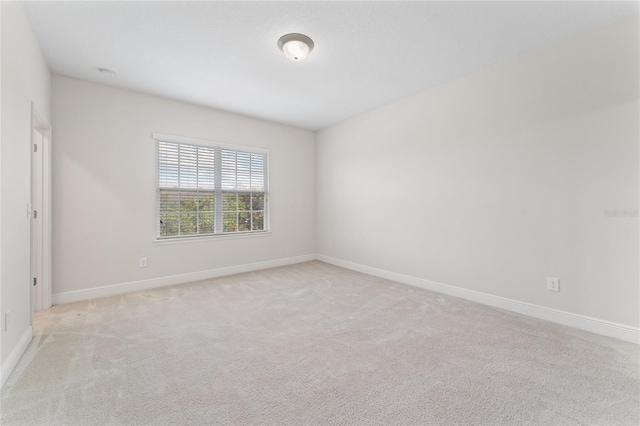 spare room featuring light colored carpet