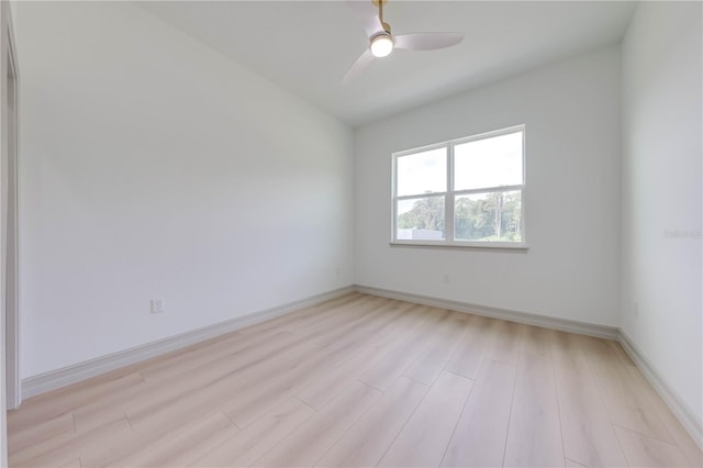 empty room with ceiling fan, vaulted ceiling, and light hardwood / wood-style floors