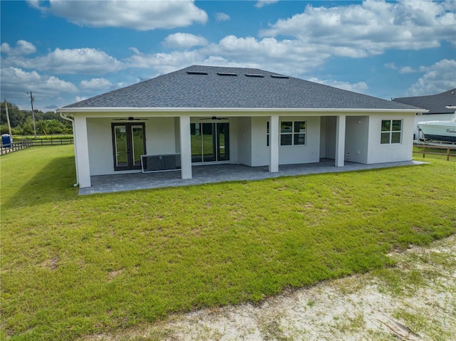 rear view of house featuring a lawn, a patio, and french doors