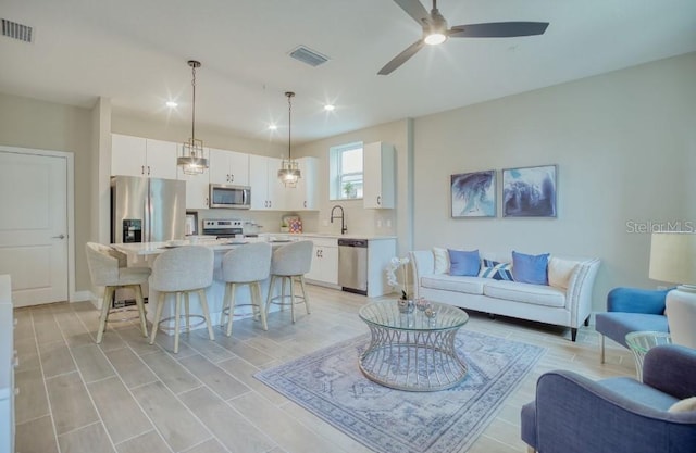 living room with ceiling fan and sink