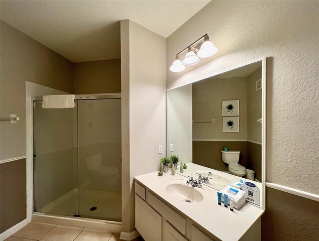 bathroom with vanity, toilet, tile patterned floors, and an enclosed shower