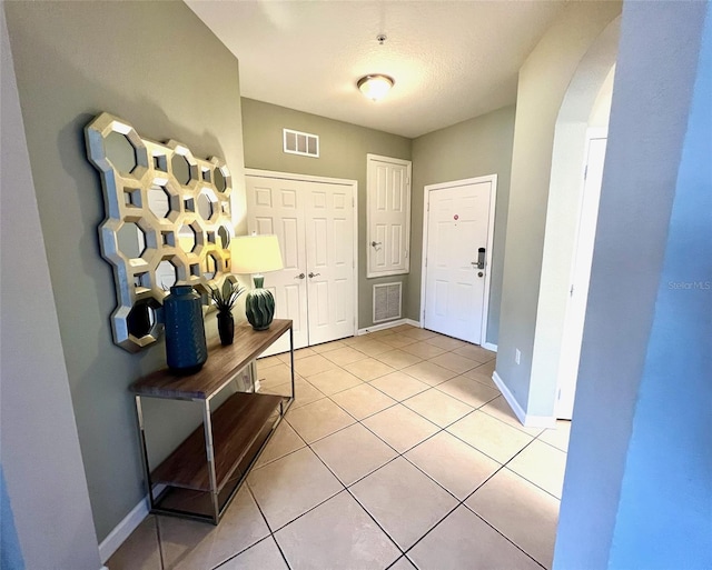 tiled entryway with a textured ceiling