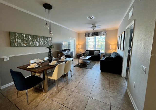 dining space featuring ceiling fan, tile patterned floors, and crown molding