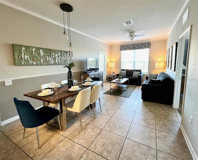 dining room with crown molding, light tile patterned floors, and ceiling fan