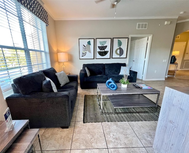 living room featuring crown molding, light tile patterned flooring, and ceiling fan