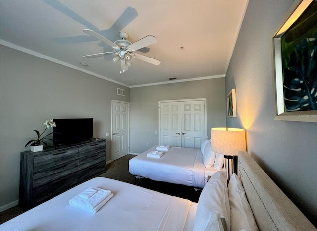 bedroom featuring crown molding, dark colored carpet, ceiling fan, and a closet