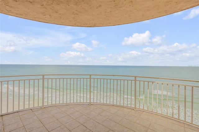 balcony featuring a water view and a beach view