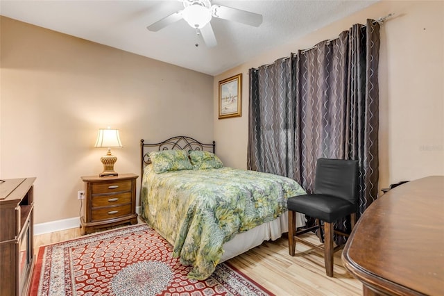 bedroom with baseboards, wood finished floors, and a ceiling fan