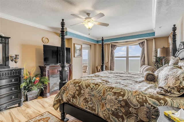 bedroom featuring a textured ceiling, crown molding, ceiling fan, and wood finished floors