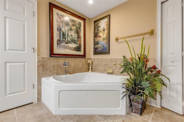 full bath featuring a bath, tile patterned floors, and tile walls