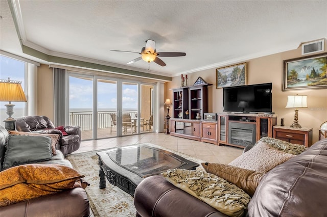 living room featuring visible vents, ornamental molding, a ceiling fan, a textured ceiling, and tile patterned flooring