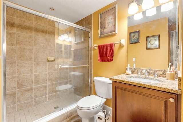 bathroom featuring vanity, toilet, and a stall shower