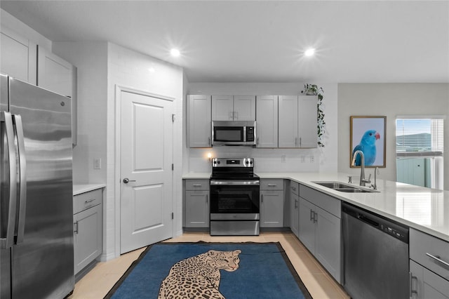 kitchen with gray cabinets, stainless steel appliances, and sink