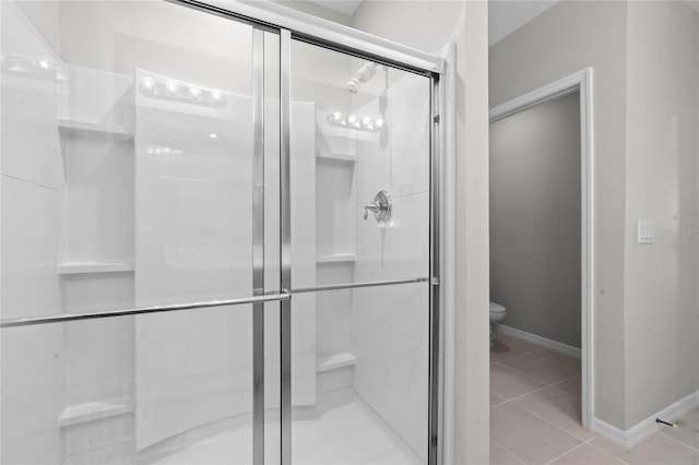 bathroom featuring tile patterned flooring, walk in shower, and toilet