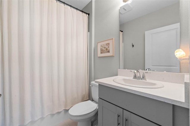 full bathroom with vanity, shower / tub combo, and toilet