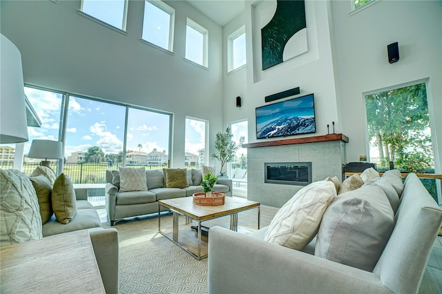 living room featuring a tile fireplace and a towering ceiling