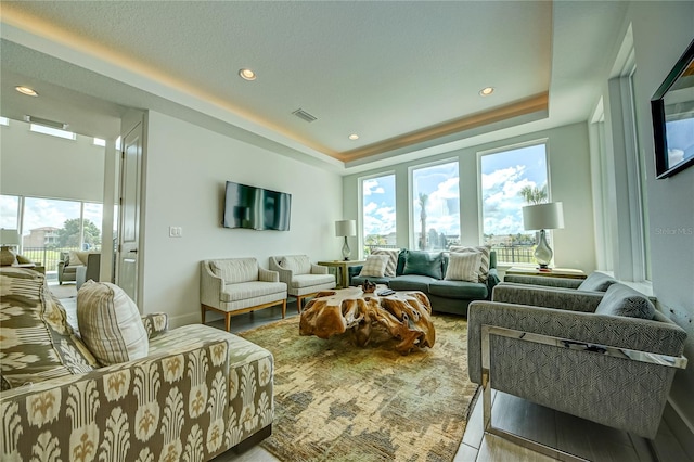 living room featuring light hardwood / wood-style floors and a tray ceiling