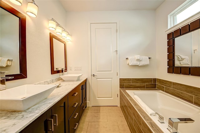 full bath with double vanity, a garden tub, tile patterned floors, and a sink