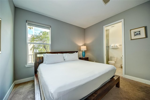 carpeted bedroom with baseboards, multiple windows, and connected bathroom