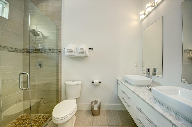 bathroom featuring toilet, an enclosed shower, and vanity