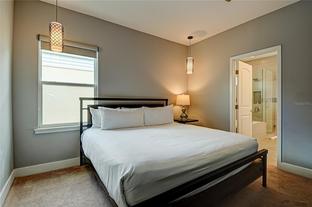 carpeted bedroom featuring ensuite bathroom and multiple windows