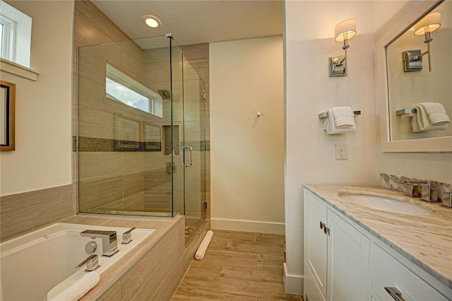 full bathroom featuring a shower stall, a garden tub, wood finished floors, vanity, and recessed lighting