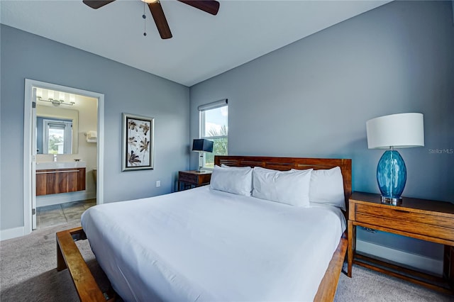 carpeted bedroom featuring ensuite bath and ceiling fan