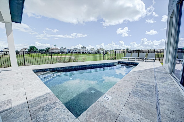 view of swimming pool with a residential view, a fenced in pool, a patio, and a fenced backyard