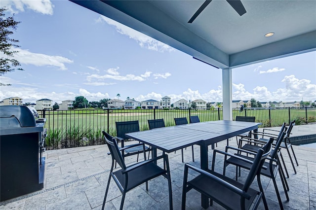 view of patio / terrace featuring a ceiling fan, area for grilling, a fenced backyard, a residential view, and outdoor dining space
