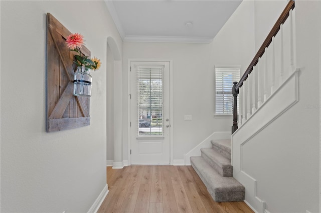 foyer featuring light wood-type flooring and crown molding