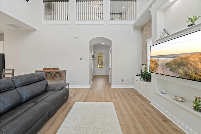 living room with a high ceiling and light hardwood / wood-style floors