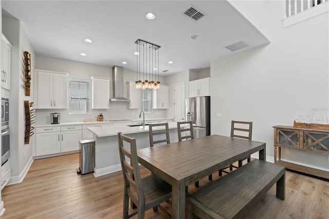 dining area featuring sink and light hardwood / wood-style flooring