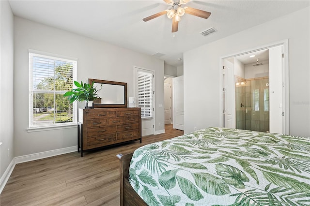 bedroom with ensuite bath, ceiling fan, and hardwood / wood-style flooring