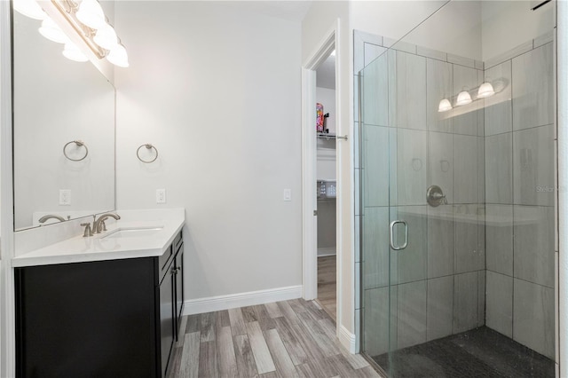 bathroom with vanity, hardwood / wood-style floors, and a shower with door